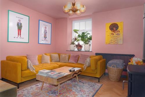a living room with two yellow couches and a table at Old Chapel Llanfrynach in Brecon