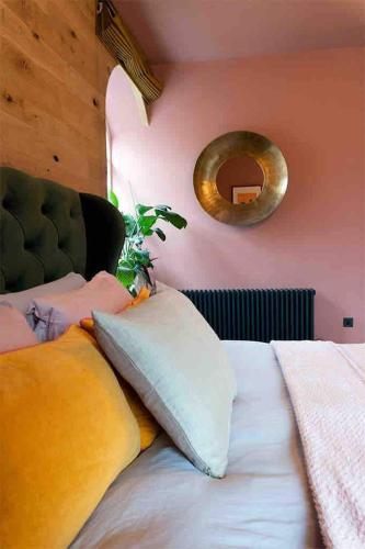 a bedroom with a bed with pillows and a mirror at Old Chapel Llanfrynach in Brecon