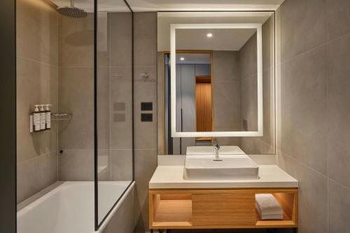 a bathroom with a sink and a shower and a mirror at AC Hotel by Marriott Split in Split
