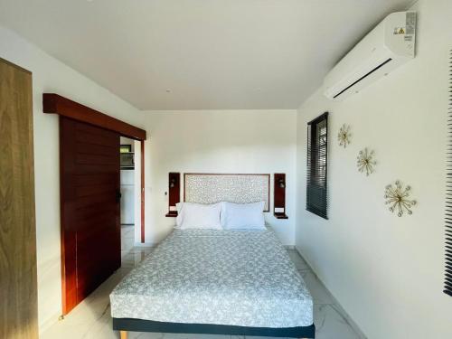 a bedroom with a bed in a white room at Fare Moorea in Moorea