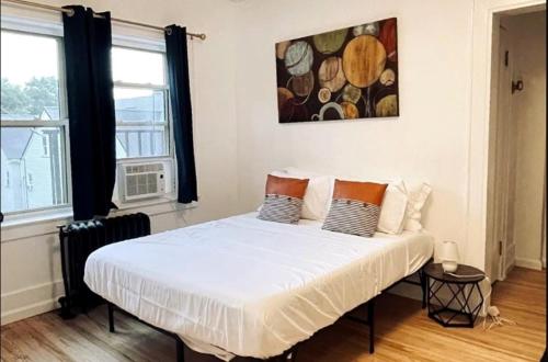 a bedroom with a large white bed with two windows at Studio Downtownhighfallskitchentvunitypet in Rochester