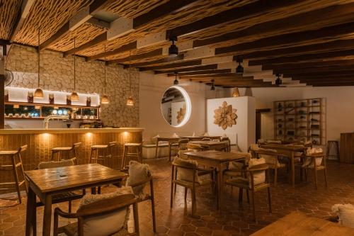 a restaurant with wooden tables and chairs and a bar at Quma Boutique Hotel - Adults Only in Gili Trawangan