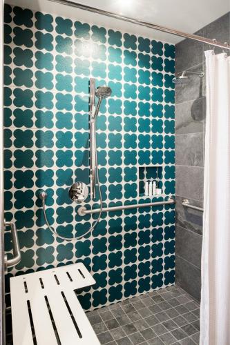 a bathroom with a shower with blue and white tiles at Hotel Nia, Autograph Collection in Menlo Park