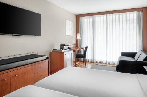 a hotel room with a bed and a flat screen tv at AC Hotel La Rioja by Marriott in Logroño