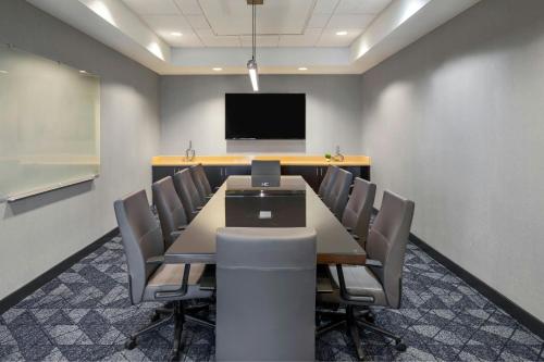 a conference room with a table and chairs and a tv at Courtyard Long Beach Airport in Long Beach