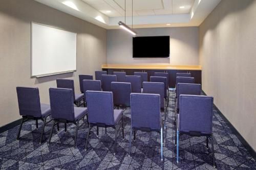 a conference room with purple chairs and a screen at Courtyard Long Beach Airport in Long Beach