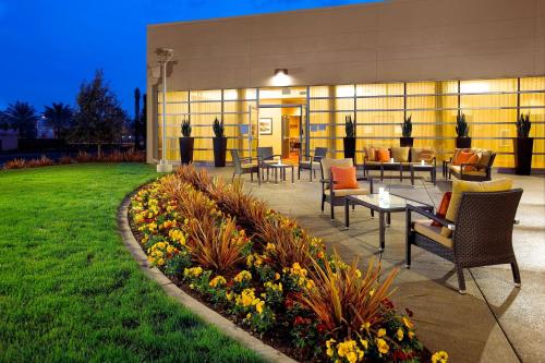 a patio with chairs and tables in front of a building at Courtyard Long Beach Airport in Long Beach