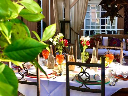 a table with a white table cloth and flowers on it at Casa Culinaria - The Gourmet Inn in Santa Fe