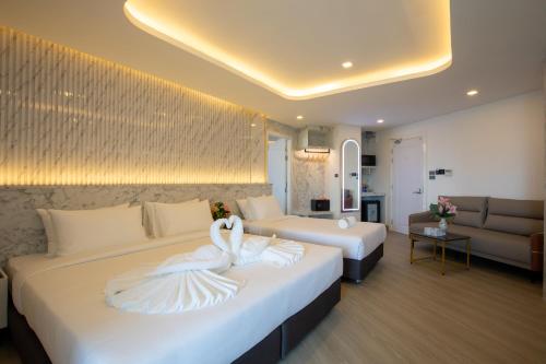a hotel room with two beds with white towels at Airbus Hotel At Phawana Station in Bangkok