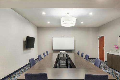 a conference room with a table and chairs and a white screen at Courtyard Rockaway-Mount Arlington in Mount Arlington