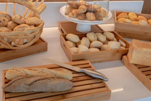 Una mesa cubierta con cajas de madera llenas de diferentes tipos de pan. en AC Hotel By Marriott Santa Marta, en Santa Marta