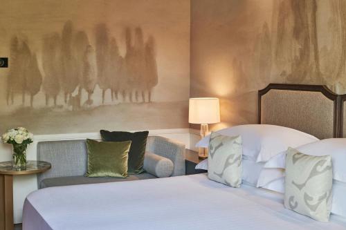 a hotel room with a bed and a chair and a couch at Grotta Giusti Thermal Spa Resort Tuscany, Autograph Collection in Monsummano