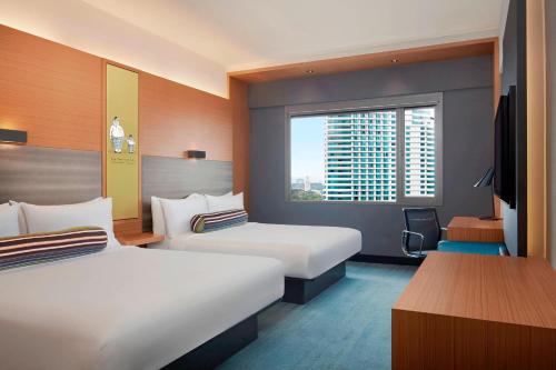 a hotel room with two beds and a window at Aloft Kuala Lumpur Sentral in Kuala Lumpur