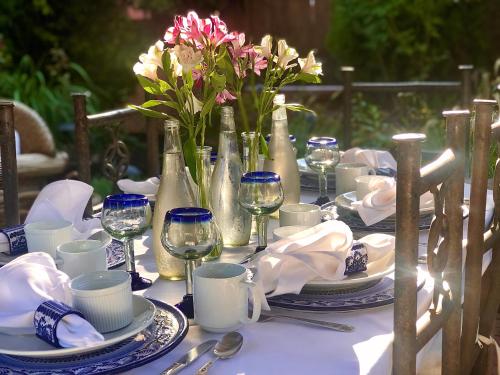 a table with blue and white plates and wine glasses at Casa Culinaria - The Gourmet Inn in Santa Fe
