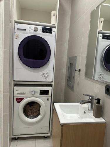 a bathroom with a washing machine and a sink at Apartments on Shevchenko in Tashkent