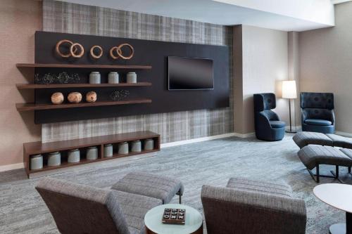 a living room with a couch and a tv at Courtyard Omaha Downtown/Old Market Area in Omaha