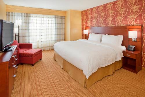 a hotel room with a large bed and a television at Courtyard by Marriott Pittsburgh North/Cranberry Woods in Cranberry Township