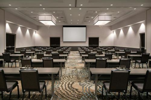 a large room with tables and chairs and a screen at Courtyard by Marriott Scottsdale Salt River in Scottsdale