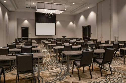 a room with tables and chairs and a projection screen at Courtyard by Marriott Scottsdale Salt River in Scottsdale