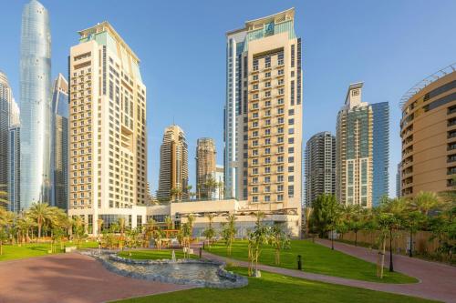 a city skyline with tall buildings and a park at Al Habtoor Grand Resort, Autograph Collection in Dubai