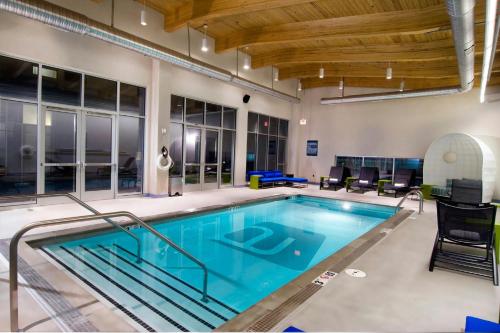 a large indoor pool with blue water and wooden ceilings at Aloft Chesapeake in Chesapeake