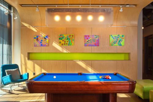 a billiard room with a pool table and chairs at Aloft Chesapeake in Chesapeake