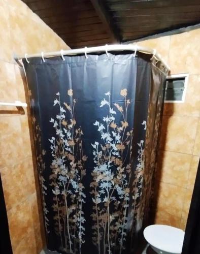a shower curtain with flowers on it in a bathroom at Cápsula 127 in Puerto Iguazú