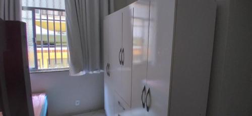 a white cabinet in a room with a window at Apartamento para temporada em Cabo Frio in Cabo Frio