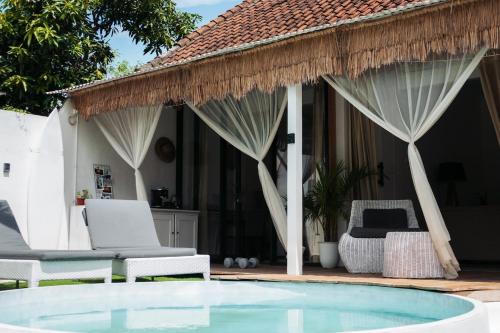 a resort with a pool and chairs and a house at Tropical Oasis Villa Bukit Bali 2 Pools Golf Cart in Jimbaran