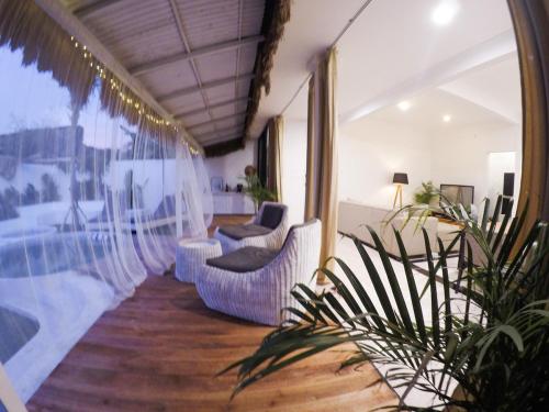 a room with white chairs and a balcony with a pool at Tropical Oasis Villa Bukit Bali 2 Pools Golf Cart in Jimbaran