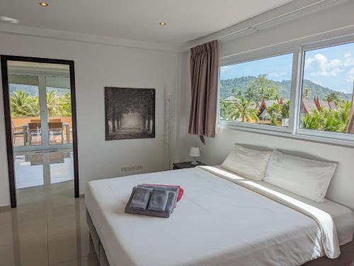 Una cama blanca con una bolsa en un dormitorio en Poolside Villa - by KohChangVillas, en Ban Khlong Son