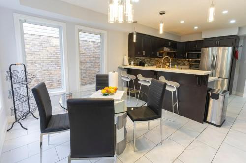 a kitchen with black cabinets and a table and chairs at An Ideal Home Away From Home in London