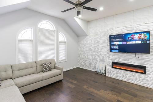 a living room with a couch and a flat screen tv at An Ideal Home Away From Home in London