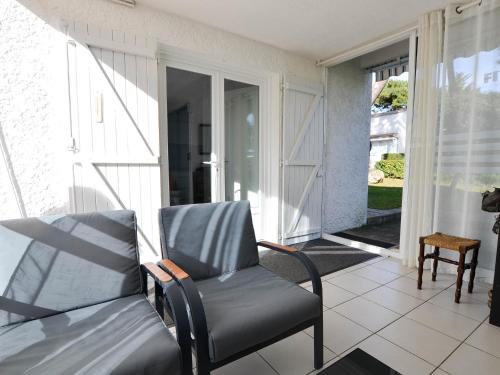 une véranda avec une chaise et une porte coulissante en verre dans l'établissement Maison 4 pièces à étage - Proche mer - Patio, BBQ - Parking - FR-1-705-94, aux Mathes