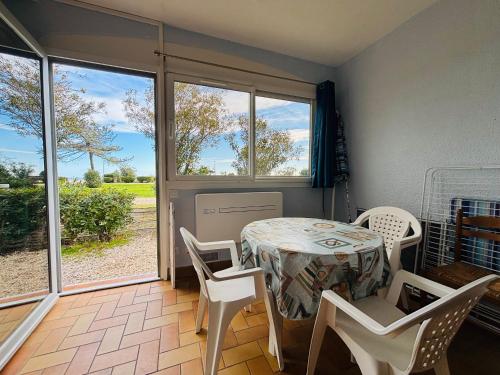 une salle à manger avec une table, des chaises et des fenêtres dans l'établissement ARGELES SUR MER - Appartement T2 Bis face à la plage - FR-1-309-494, à Argelès-sur-Mer