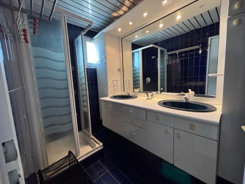 une salle de bain avec deux lavabos et un grand miroir dans l'établissement T4 en Front de Mer pour 6 pers avec Climatisation et Parking à Narbonne-Plage - FR-1-795-58, à Narbonne