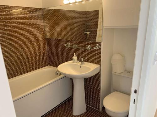 une salle de bain avec un lavabo, des toilettes et une baignoire dans l'établissement Appartement 2 pièces avec piscine pour 4 personnes - FR-1-731-116, au Grau-du-Roi