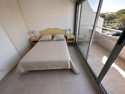 une chambre avec un lit et une grande fenêtre dans l'établissement Appartement familial 6 pers à Port Camargue avec parking - FR-1-731-123, au Grau-du-Roi