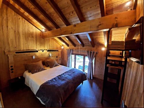 Un dormitorio con una cama en una habitación de madera. en Chalet 5* pied des pistes Spa - FR-1-267-308, en Villarembert