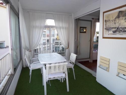 une table blanche et des chaises dans une pièce avec une fenêtre dans l'établissement Cap d'Agde: Appt 3 pièces avec vue imprenable - FR-1-723-168, au Cap d'Agde
