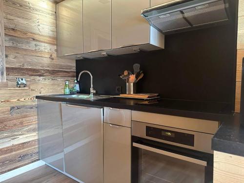 d'une cuisine avec des appareils en acier inoxydable et des murs en bois. dans l'établissement Chaleureux appartement duplex 3 chambres avec parking, Bolquère - FR-1-592-82, à Font-Romeu-Odeillo-Via