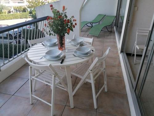 une table blanche et des chaises sur un balcon dans l'établissement Bel Appartement 4 Pers avec Clim & Parking, Port Camargue - FR-1-731-119, au Grau-du-Roi