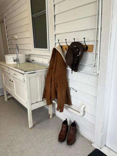 a bathroom with a sink and a mirror and shoes at The Backhouse in Eden