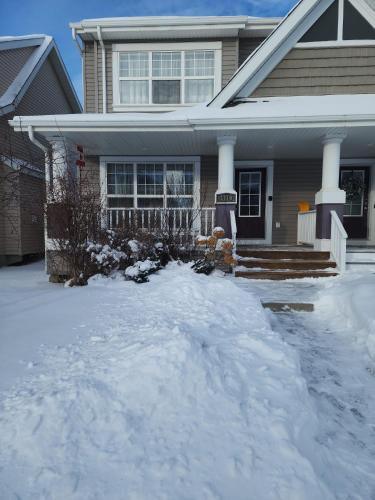 a house with a pile of snow in front of it at Cozy Luxury House in Edmonton