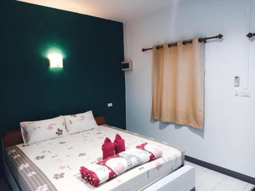 ein Schlafzimmer mit einem Bett mit roten Bögen darauf in der Unterkunft Bansuan Sukcharoen at Kuraburi in Khura Buri