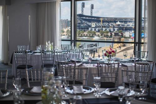 a room with tables and chairs with a view of a city at Renaissance Pittsburgh Hotel in Pittsburgh