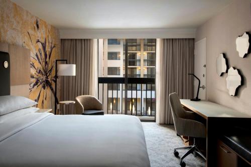 a hotel room with a bed and a desk and a window at Westchester Marriott in Tarrytown