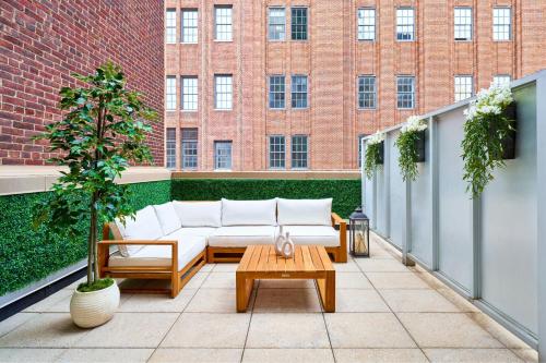 a patio with a couch and a coffee table on a balcony at Sheraton Tribeca New York Hotel in New York