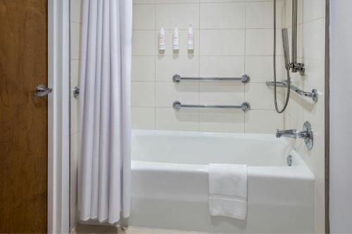 a bathroom with a bath tub with a shower curtain at Westchester Marriott in Tarrytown