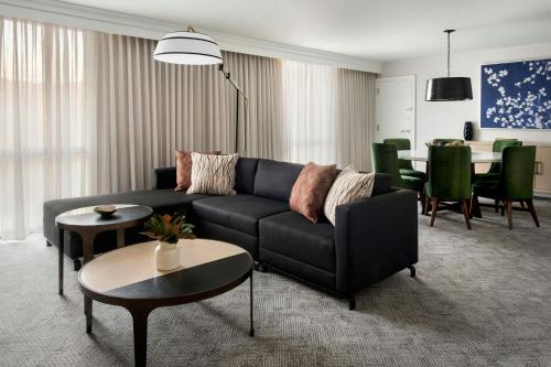 a living room with a black couch and a table at Westchester Marriott in Tarrytown